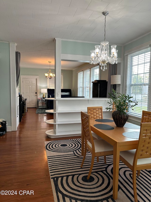 dining area featuring an inviting chandelier, ornamental molding, and wood-type flooring