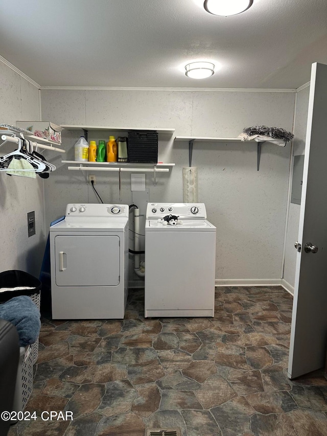 clothes washing area with tile patterned floors, washing machine and dryer, and crown molding