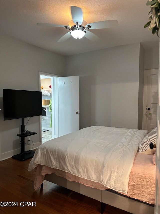 bedroom featuring ceiling fan, hardwood / wood-style floors, and connected bathroom