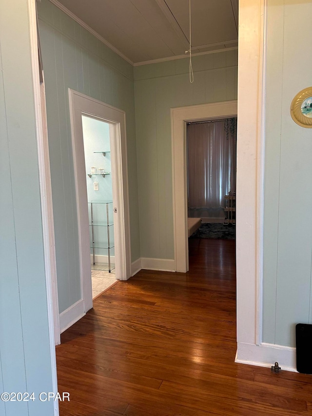 hall with wood-type flooring and ornamental molding