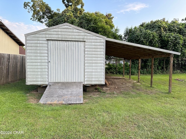 view of outdoor structure featuring a carport and a yard