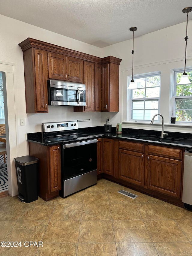 kitchen with sink, stainless steel appliances, and light tile patterned flooring