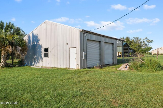 view of outdoor structure with a lawn and a garage