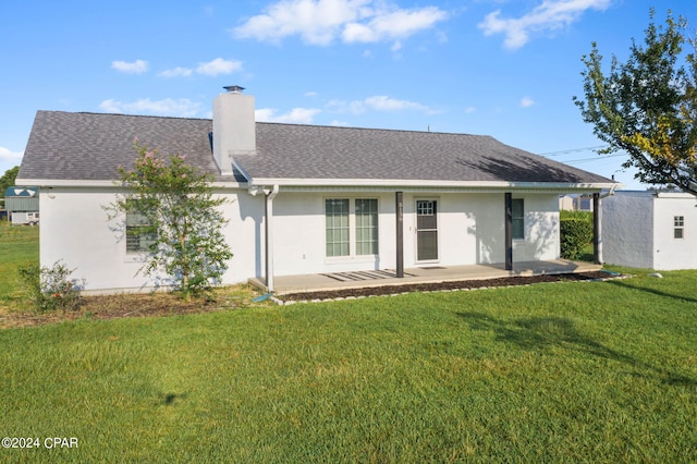 back of house with a patio area and a lawn