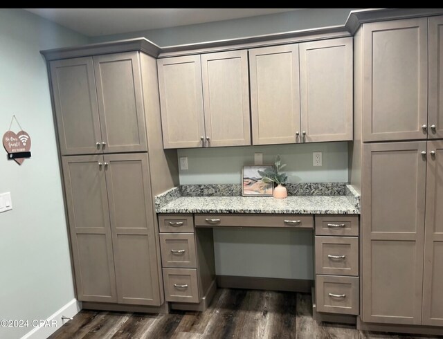 interior space with light stone counters, dark hardwood / wood-style flooring, and gray cabinetry