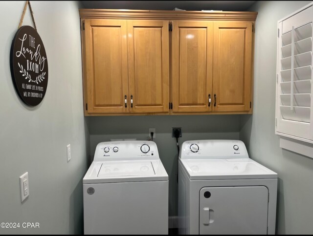 washroom featuring cabinets and washing machine and clothes dryer