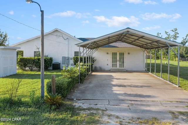 back of property with cooling unit, a lawn, and french doors