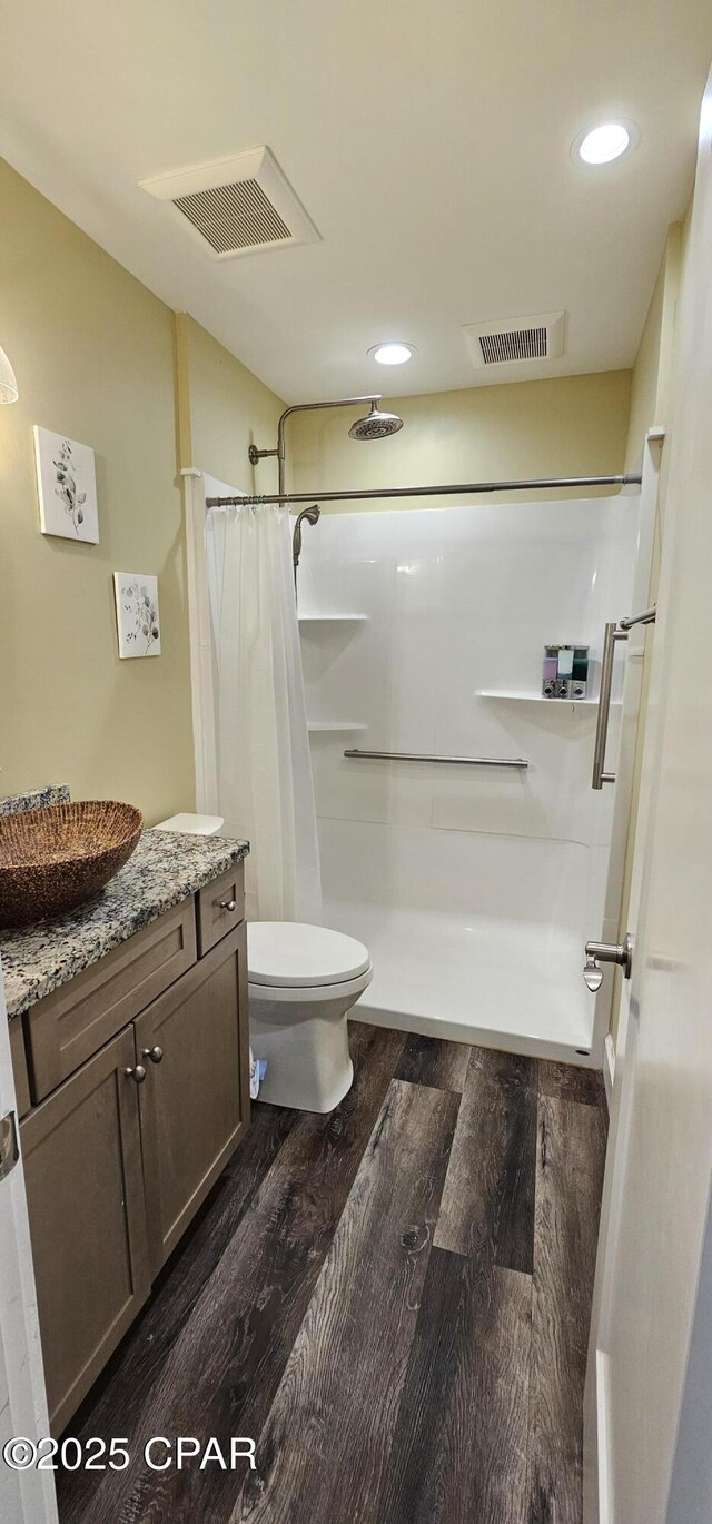 bathroom with wood-type flooring, toilet, vanity, and a shower with shower curtain