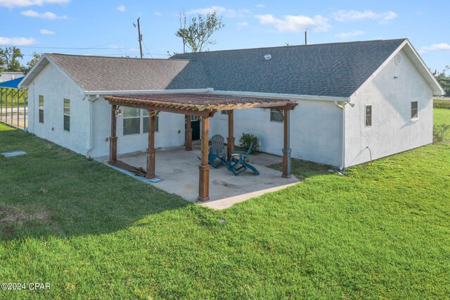 back of property with a pergola, a patio, and a lawn