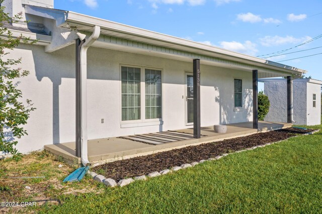 rear view of property featuring a patio and a lawn