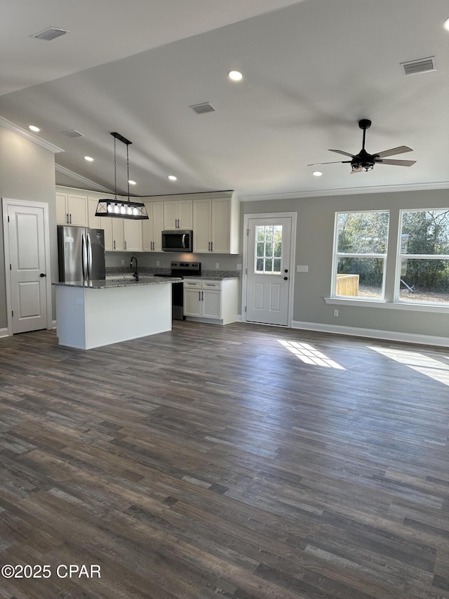 kitchen featuring an island with sink, stainless steel appliances, dark hardwood / wood-style flooring, vaulted ceiling, and pendant lighting