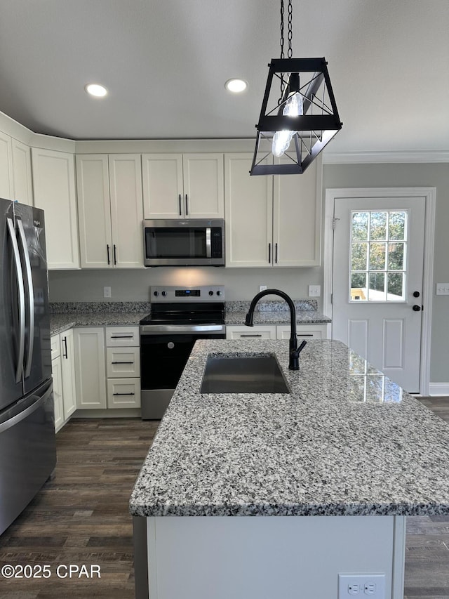 kitchen featuring dark wood finished floors, appliances with stainless steel finishes, white cabinetry, and a sink