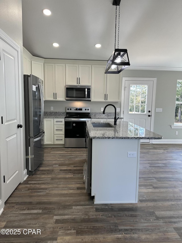 kitchen with light stone countertops, white cabinets, pendant lighting, and appliances with stainless steel finishes