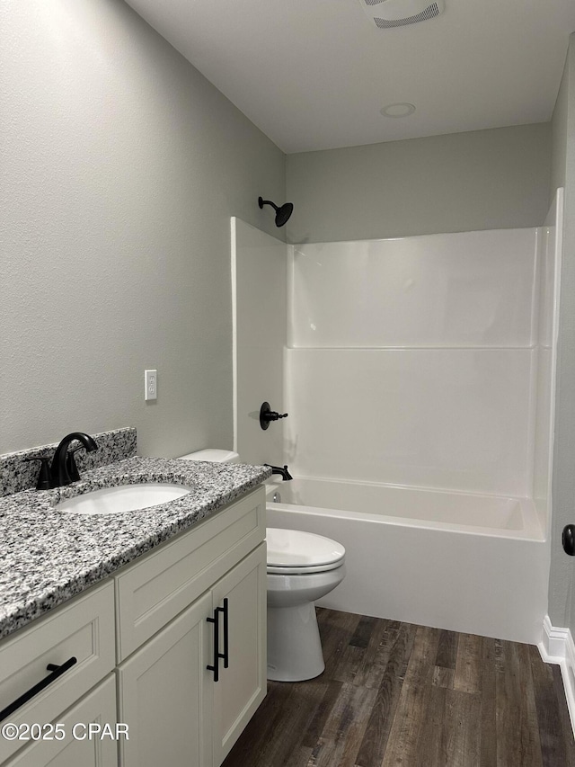 full bathroom with visible vents, tub / shower combination, toilet, wood finished floors, and vanity
