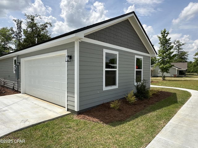 view of side of home featuring a lawn, driveway, and a garage