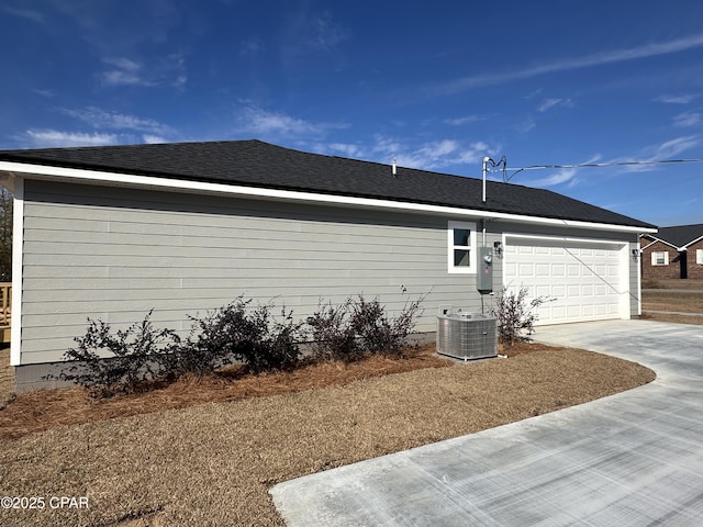 view of side of property featuring a garage and central AC