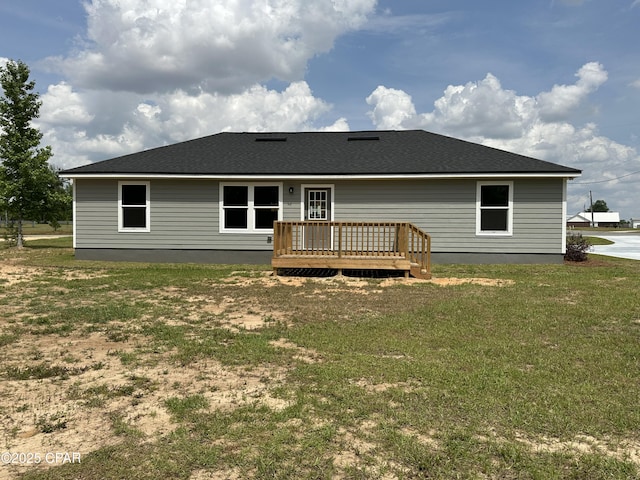 rear view of property with a lawn and a wooden deck
