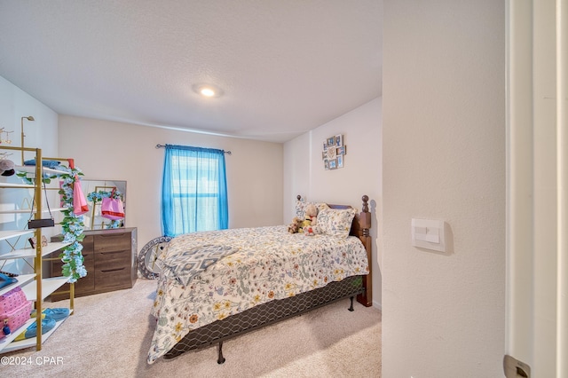 bedroom featuring light colored carpet and a textured ceiling