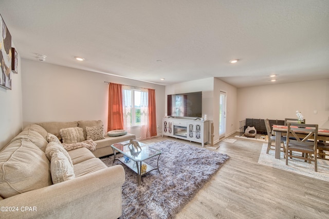 living room with light hardwood / wood-style floors and a textured ceiling