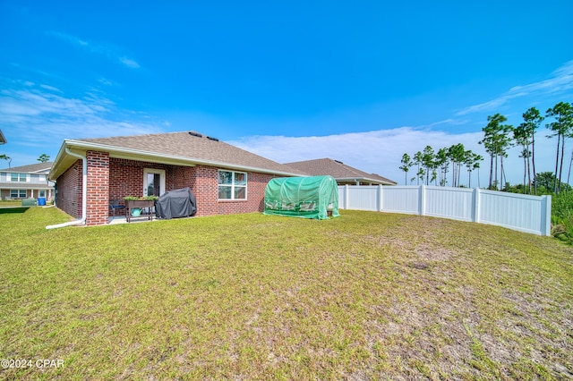 back of property featuring a lawn and a patio