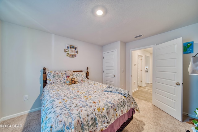 bedroom featuring carpet floors and a textured ceiling