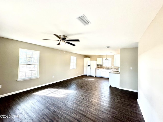 unfurnished living room featuring ceiling fan, dark hardwood / wood-style flooring, and sink