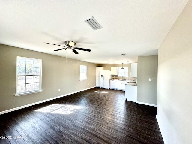 unfurnished living room featuring ceiling fan, dark hardwood / wood-style flooring, sink, and a textured ceiling