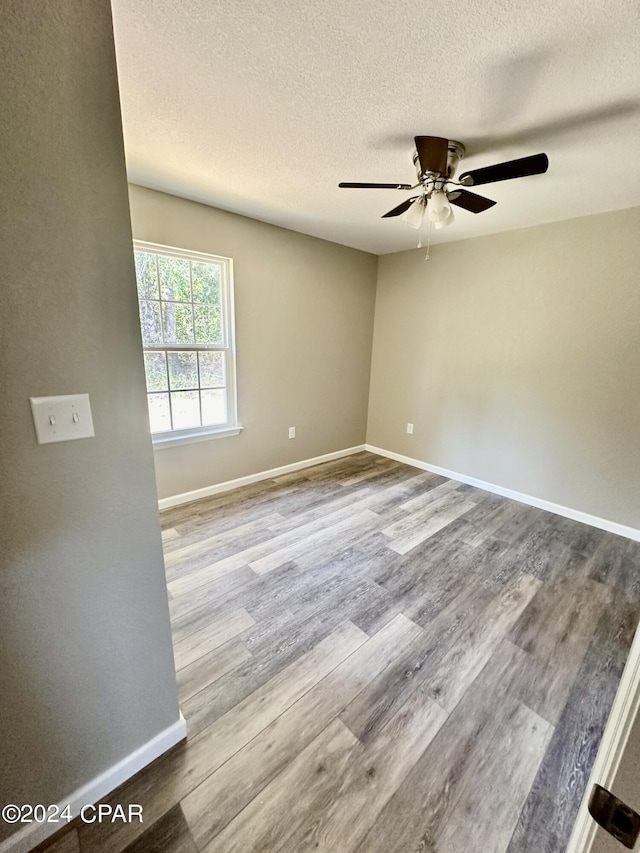 unfurnished room featuring a textured ceiling, ceiling fan, and light hardwood / wood-style flooring