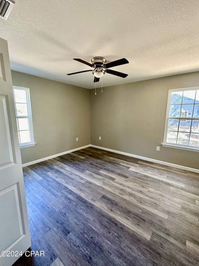 spare room featuring ceiling fan, dark hardwood / wood-style floors, and a textured ceiling