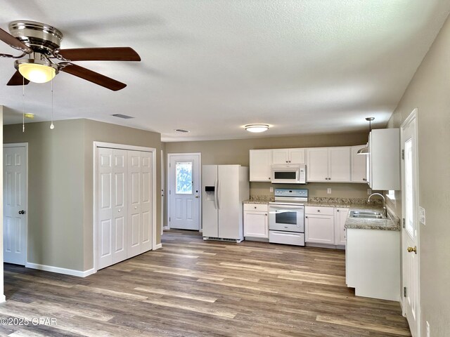 unfurnished living room with a textured ceiling, ceiling fan, sink, and dark hardwood / wood-style floors