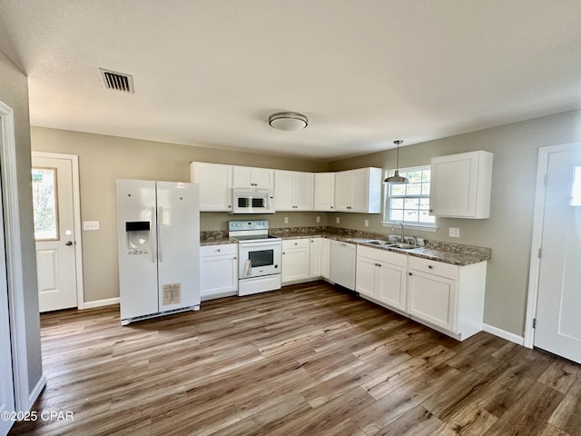 kitchen with pendant lighting, sink, white cabinets, hardwood / wood-style flooring, and white appliances