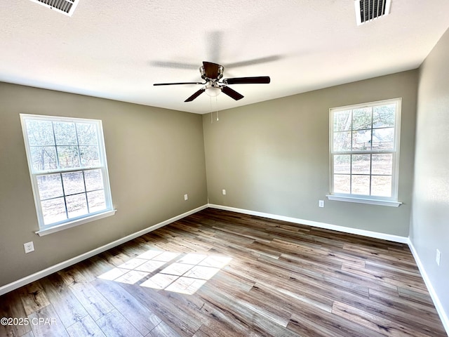 unfurnished room with ceiling fan, a textured ceiling, light hardwood / wood-style flooring, and a healthy amount of sunlight