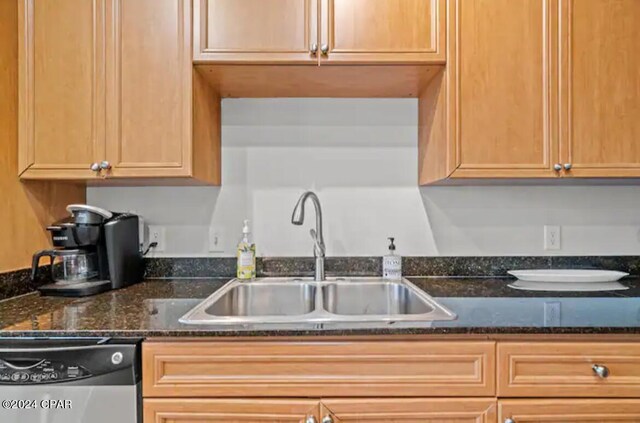 kitchen featuring dark stone counters, sink, and dishwasher