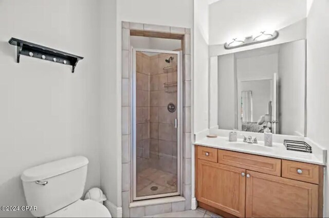 bathroom featuring toilet, vanity, walk in shower, and tile patterned floors