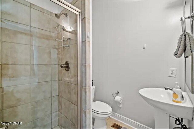 bathroom with toilet and a shower with door