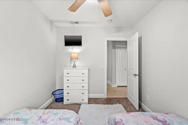 tiled bedroom featuring ceiling fan