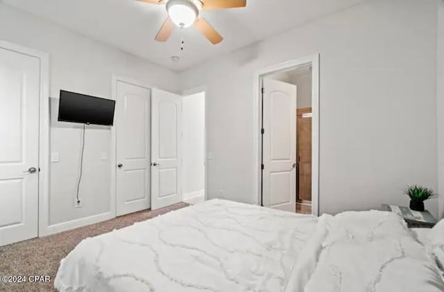 carpeted bedroom with ceiling fan and ensuite bathroom