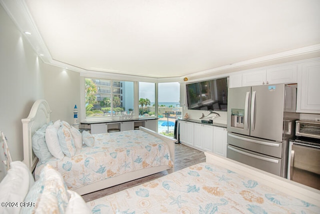 bedroom featuring light wood-type flooring, stainless steel fridge, and crown molding