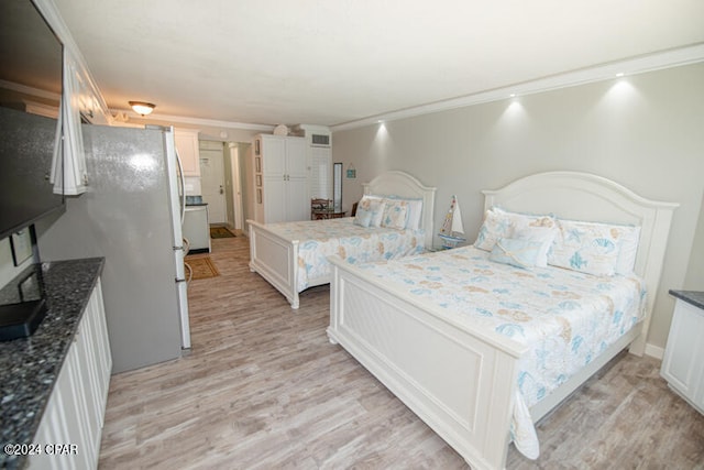 bedroom featuring white fridge, light hardwood / wood-style flooring, and ornamental molding