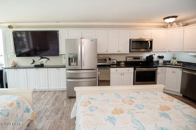 kitchen with white cabinets, light hardwood / wood-style flooring, and appliances with stainless steel finishes