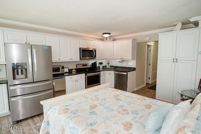 kitchen featuring white cabinetry, light hardwood / wood-style flooring, and appliances with stainless steel finishes