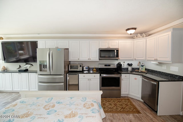 kitchen featuring sink, white cabinets, light hardwood / wood-style flooring, and appliances with stainless steel finishes