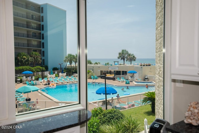 view of pool with a patio and a water view