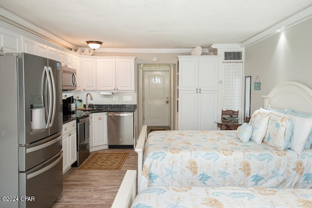 bedroom featuring sink, crown molding, light hardwood / wood-style floors, and stainless steel refrigerator with ice dispenser