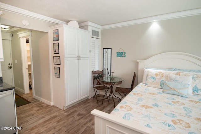 bedroom featuring a closet, crown molding, and wood-type flooring