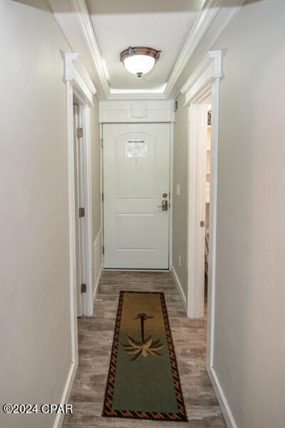 doorway to outside featuring crown molding, decorative columns, and hardwood / wood-style flooring