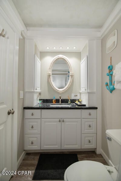 bathroom with wood-type flooring, vanity, and toilet