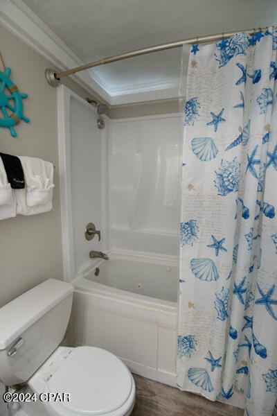 bathroom with toilet, hardwood / wood-style floors, and shower / tub combo with curtain