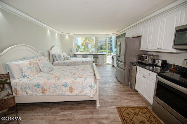 bedroom featuring light hardwood / wood-style floors, access to outside, and crown molding