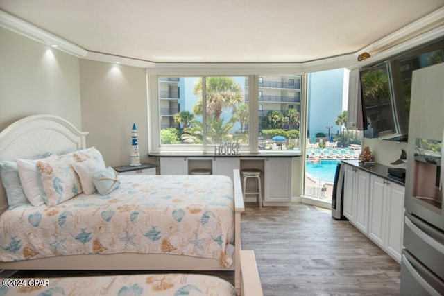 bedroom with access to outside, light hardwood / wood-style flooring, stainless steel fridge, and ornamental molding